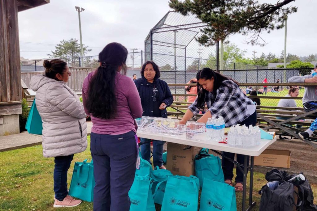 People at a table with water and goodie bags